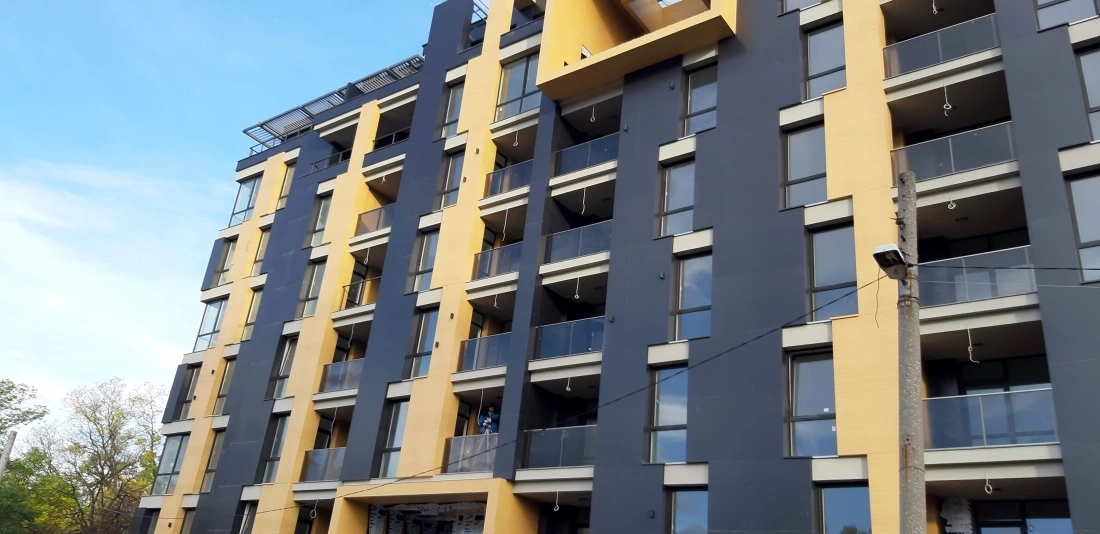 Modern architecture residential building with yellow and anthracite facade delivered by construction company Bulgaria for investment partnership with ParapetiBG