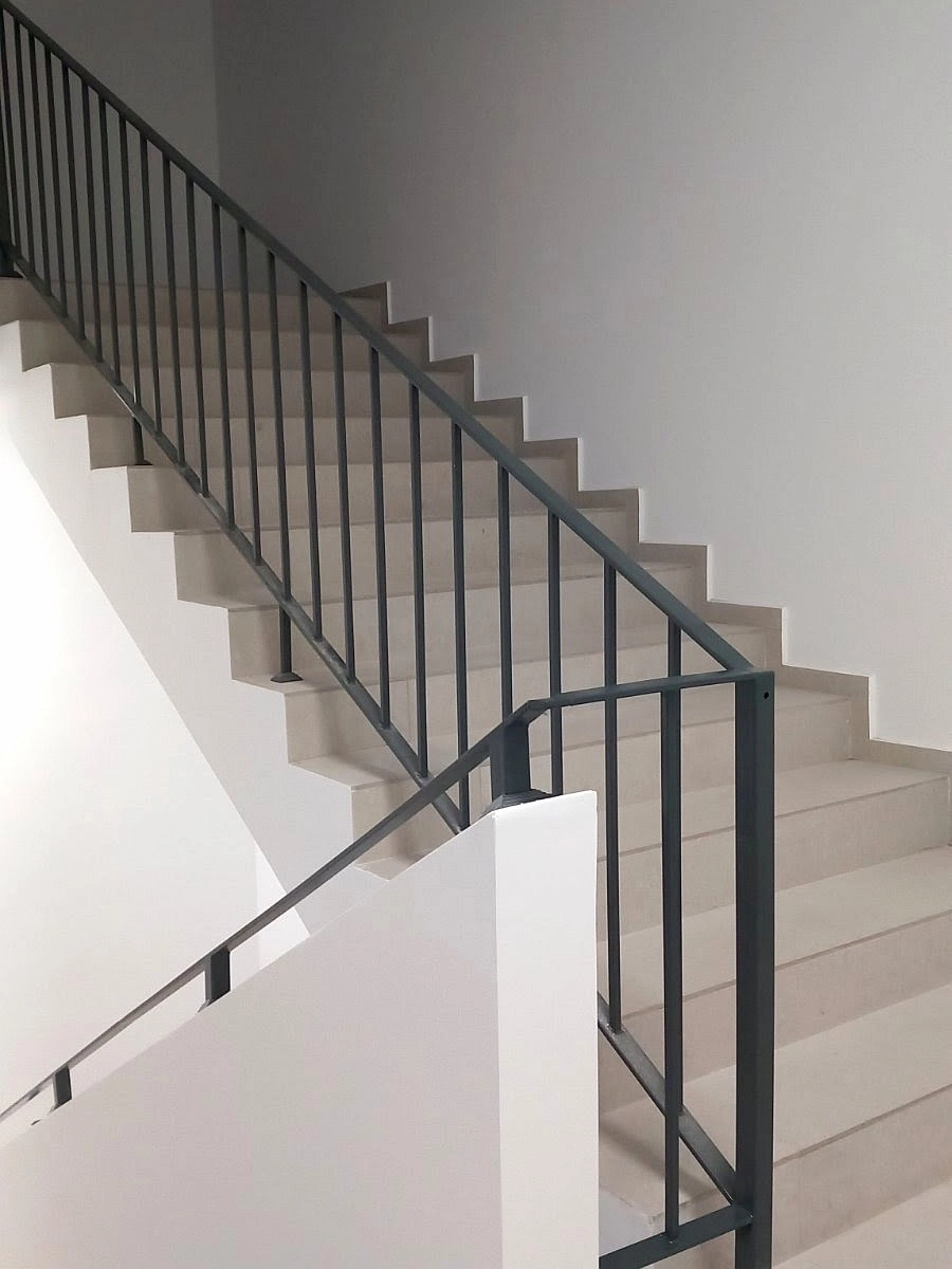 Modern interior common staircase with metal railing finished by construction subcontractor Bulgaria for partnership residential buildings